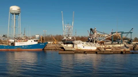 Tracking in on various boats getting worked on along river Stock Footage 101304844