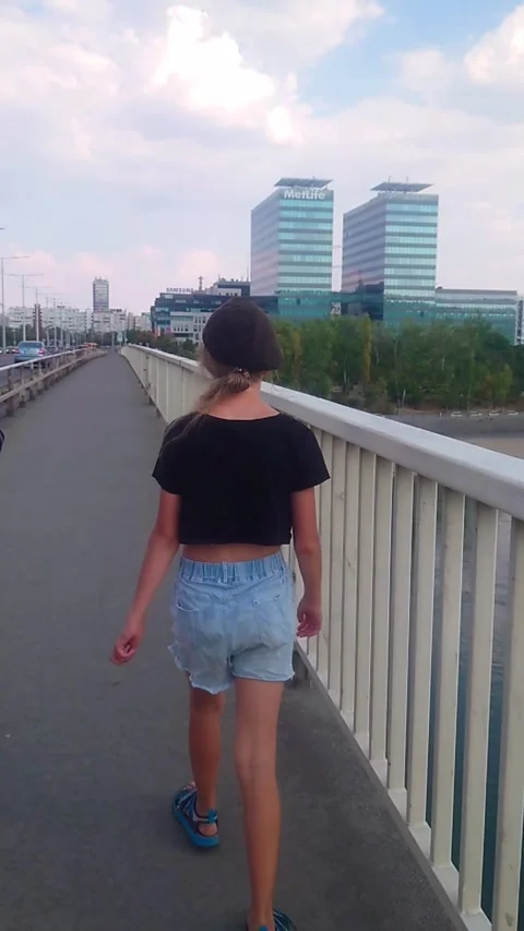 Tracking Vertical Medium Rear View of Preteen Girl Walking Across Petofi Bridge 库存影片 345031997