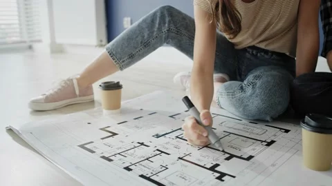 Tracking video of couple looking at blueprint in new house Stockbeeldmateriaal 134688570