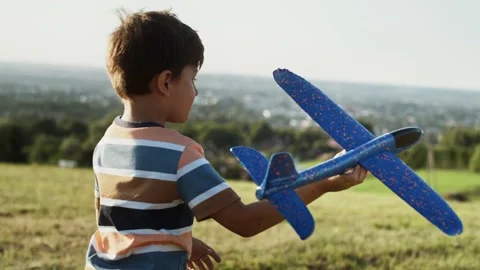 Tracking video of little boy while playing with airplane outside. Video stock 149977751