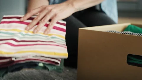 Tracking video of preparing clothes for donation. Stockbeeldmateriaal 141570123