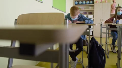 Tracking video of students writing during a pandemic. Stock Footage 153530960