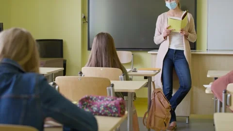 Tracking video of teacher reading to school children in class. Video stock 153531747