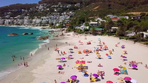 A tracking view over umbrellas and bathers on Clifton beach. Video stock 83124034