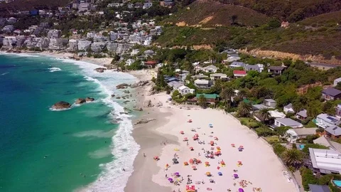 A tracking view over umbrellas and bathers on Clifton beach. Stock Footage 83130283