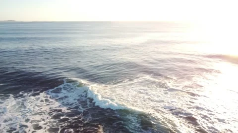 Tracking Wave Breaking over Rocks at Sunrise. Aerial Panning. Video stock 151878451