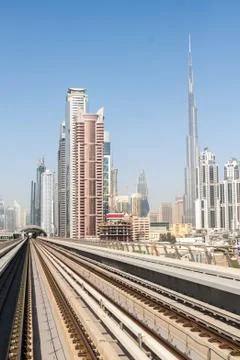 Tracks of an elevated stretch of Dubai metro and Burj Khalifa skyscraper, Uni Stock Photos