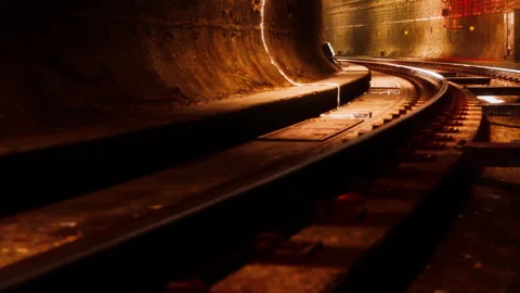 Tracks winding through a dark tunnel in a subway station under city streets Stock Footage 344971282