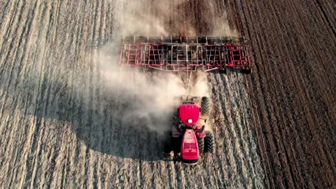 Tracto plowing ground preparing soil for palnting seeds. Agriculture farm Stock Footage 190602523
