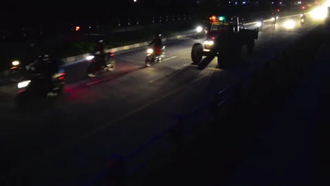 A tractor alongside a huge traffic in a highway road at night Stock Footage 248734008