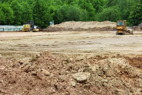 Tractor and compactor are leveling and compacting the surface of the earth. Stock Photos