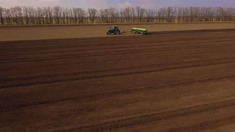 Tractor and Seeder Planting Crops on a Field Stock Footage 236950009
