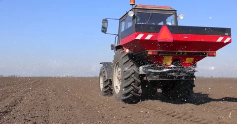 Tractor and spreader fertilizer working on arable land Video stock 236895985