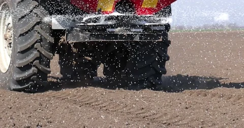 Tractor and spreader fertilizer working on arable land, slow motion Stock Footage 236896097
