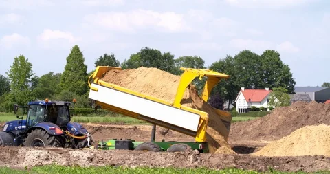 Tractor and tipping trailer dumping yellow sand at a construction site Vídeo Stock 109569376