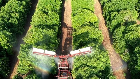 Tractor with attached spray rig applying pesticide Stock Footage 137069210