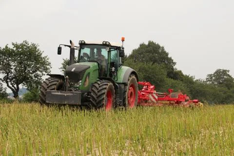 Tractor with attached tilling tool preparing field with rape stubble for fe.. Stock Photos