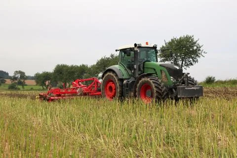 Tractor with attached tilling tool preparing field with rape stubble for fe.. Stock Photos