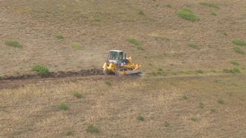Tractor breaks new ground road on the mountainside Stock Footage 224150199