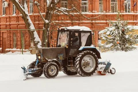 A tractor with brushes removes snow on the rink Stock Photos