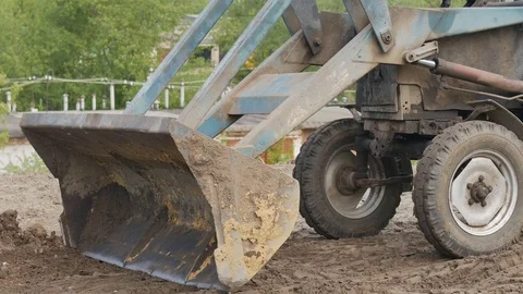 Tractor bucket level the soil in the field. Stock Footage 76491302