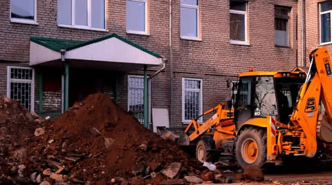 Tractor on building removes garbage, stones, sand Видео 22905647
