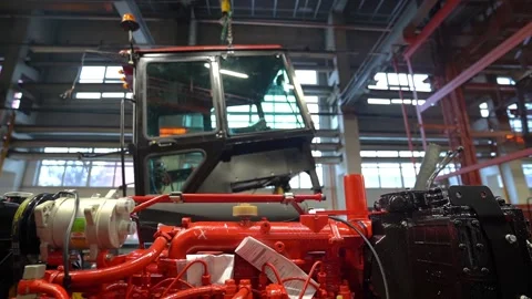 The tractor cab is suspended in the workshop on a crane beam, the engine is at  Stock Footage 148051439