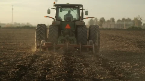 Tractor Chisel descends ands digs into ground and drive into Field Stock-Footage 94642828