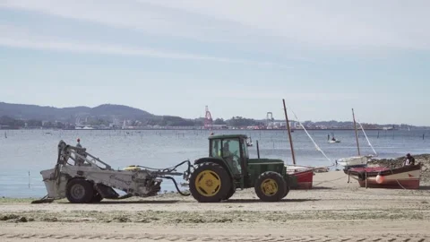 Tractor cleaning a beach with algae and garbage Видео 138044564