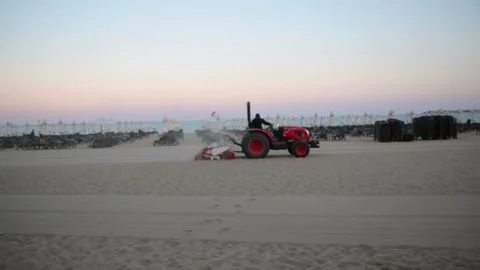 Tractor cleaning the beach during sunset Stock Footage 303512917