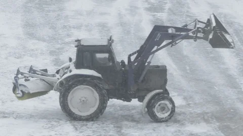 The tractor is cleaning ice from snow on ice rink at playground Stock Footage 87260905