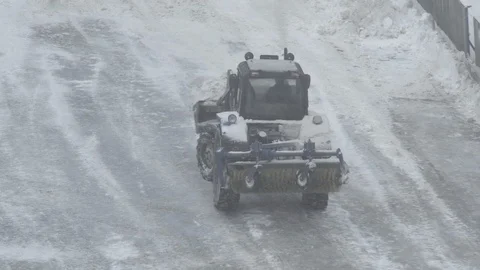 The tractor is cleaning ice from snow on ice rink at playground Stock Footage 87261013
