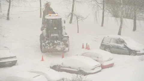 Tractor cleaning the streets from snow in snowfall Stock Footage 148530184