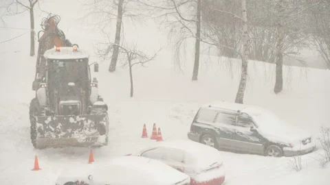 Tractor cleaning the streets from snow in snowfall Stock Footage 148532235