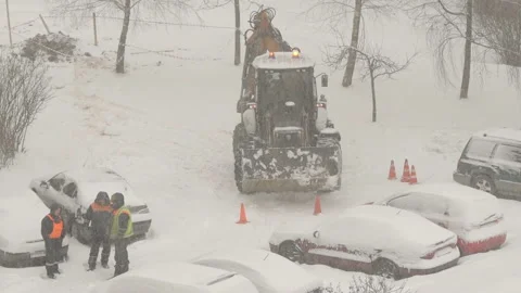 Tractor cleaning the streets from snow in snowfall Stock Footage 148544534