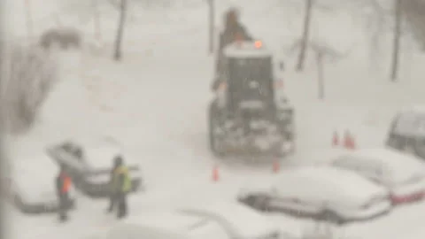 Tractor cleaning the streets from snow in snowfall Stock Footage 148546324