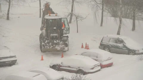 Tractor cleaning the streets from snow in snowfall Stock Footage 148549018
