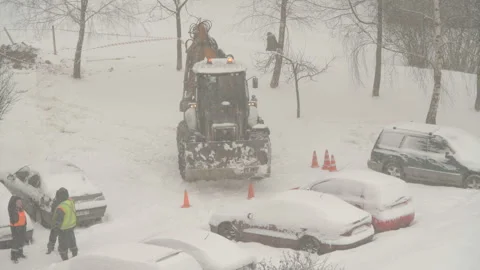 Tractor cleaning the streets from snow in snowfall Stock Footage 148549228
