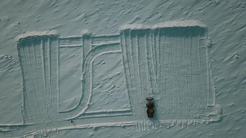 Tractor cleans snow on the river. Vertical drone view. Video stock 102479079