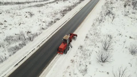Tractor cleans snow while driving on the track. aerial shooting Stock Footage 148415647