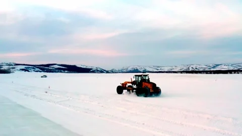 Tractor Clearing Deep Snow Across a Frozen Plain Stock Footage 344951295