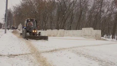 A tractor is clearing the pavement from snow Stock Footage 123166354