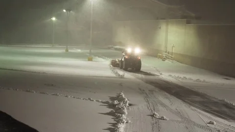 Tractor clearing snow out of parking lot Stock Footage 72415944