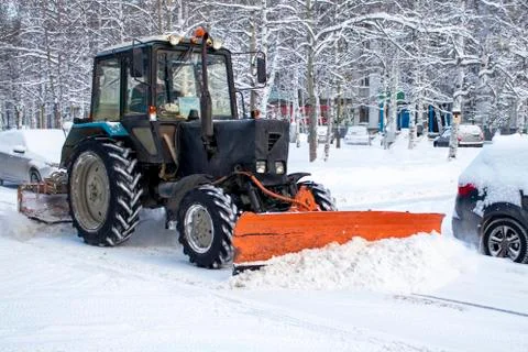 A tractor clears the road from snow. Stock Photos
