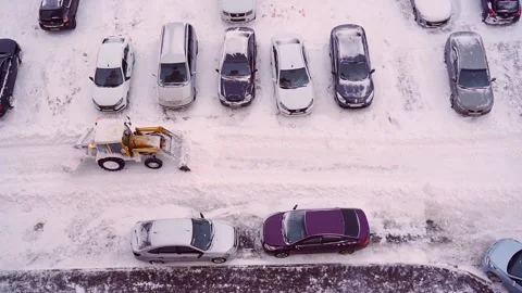 The tractor clears snow from the road with a bucket. The tractor removes snow Stock Footage 160590286