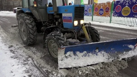 Tractor clears snow from the road in the park in slow motion Vidéo 71123416