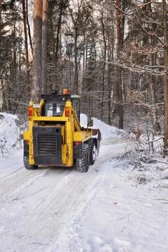 The tractor clears snow from the road Stock Photos
