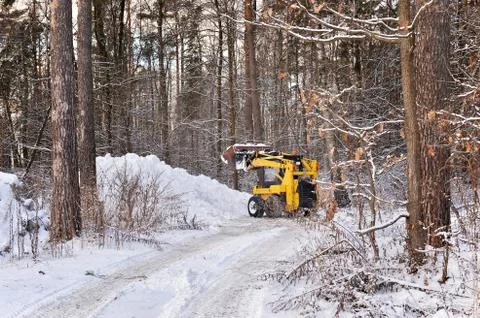 The tractor clears snow from the road Stock Photos