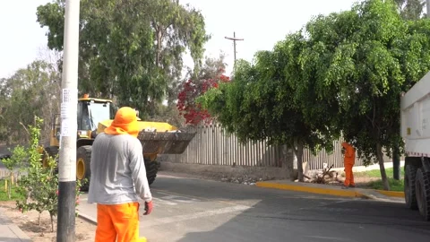 A tractor collecting and dumping garbage in a garbage truck on the street Stock Footage 149205157