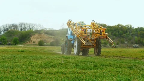 Tractor completed work in the field and rides into the distance along a rural Stock Footage 129776099